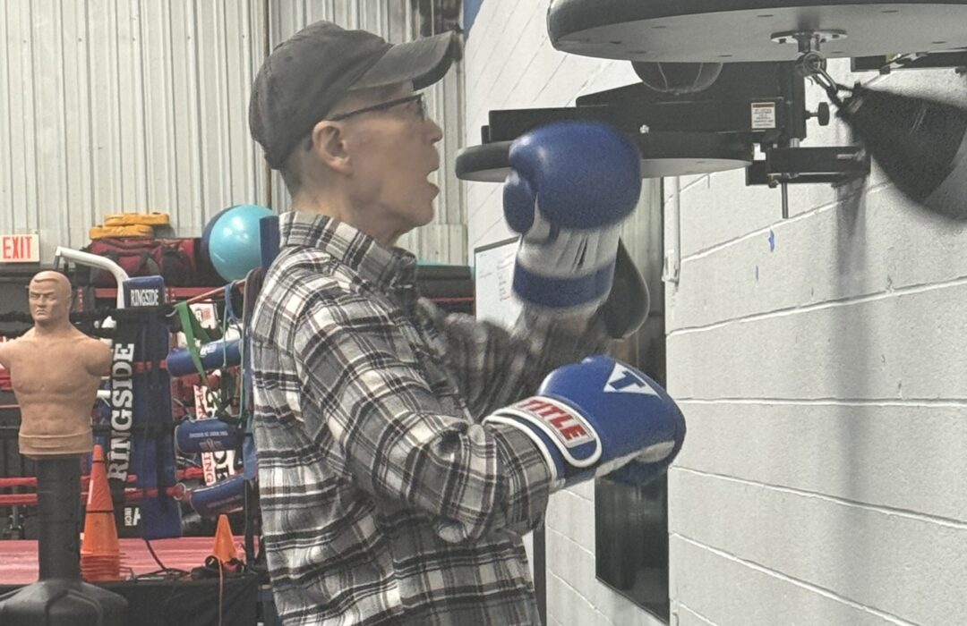 A man uses a small punching bag.